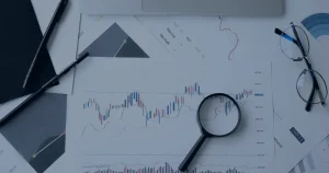 Documentos e lupa em mesa ilustrando a conformidade com a LGPD na sua empresa