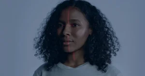 Rosto com luz projetada ilustrando deepfake e golpes digitais avançados