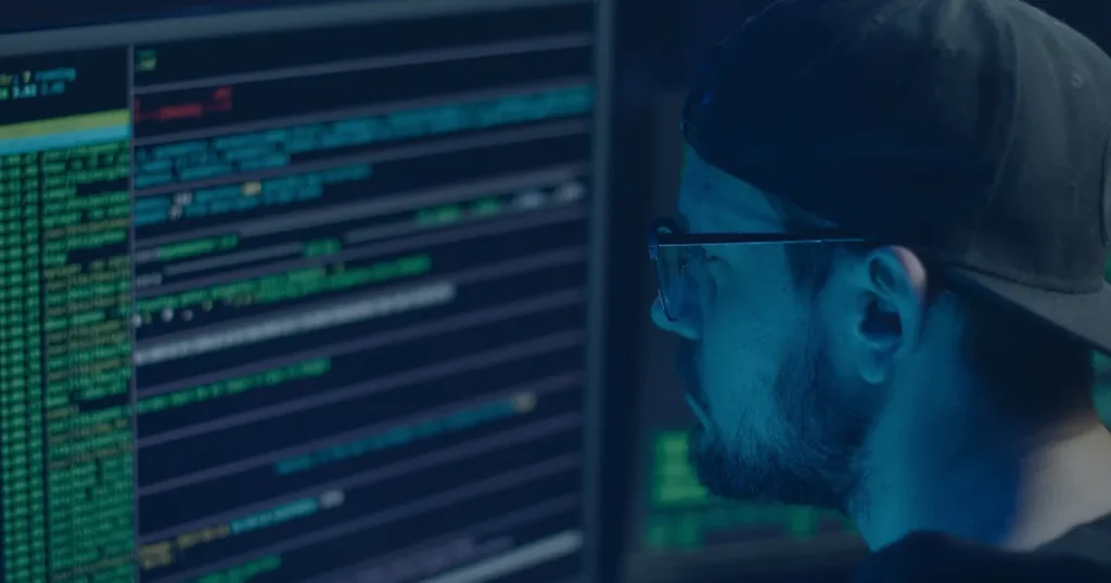 Analista diante de telas de código ilustrando a detecção de ameaças com inteligência artificial