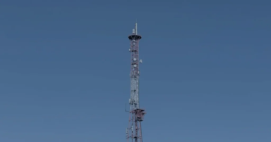 Torre de comunicação contra o céu ilustrando a evolução do 5G na infraestrutura de TI
