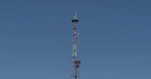 Torre de comunicação contra o céu ilustrando a evolução do 5G na infraestrutura de TI