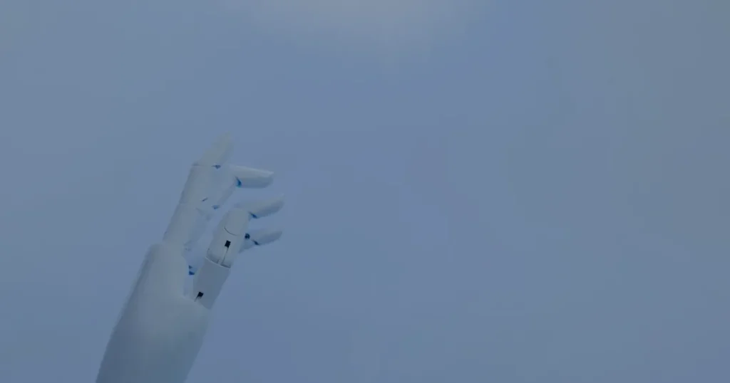 Mão robótica em luz azul ilustrando o papel da IA na gestão da infraestrutura de TI