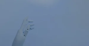 Mão robótica em luz azul ilustrando o papel da IA na gestão da infraestrutura de TI