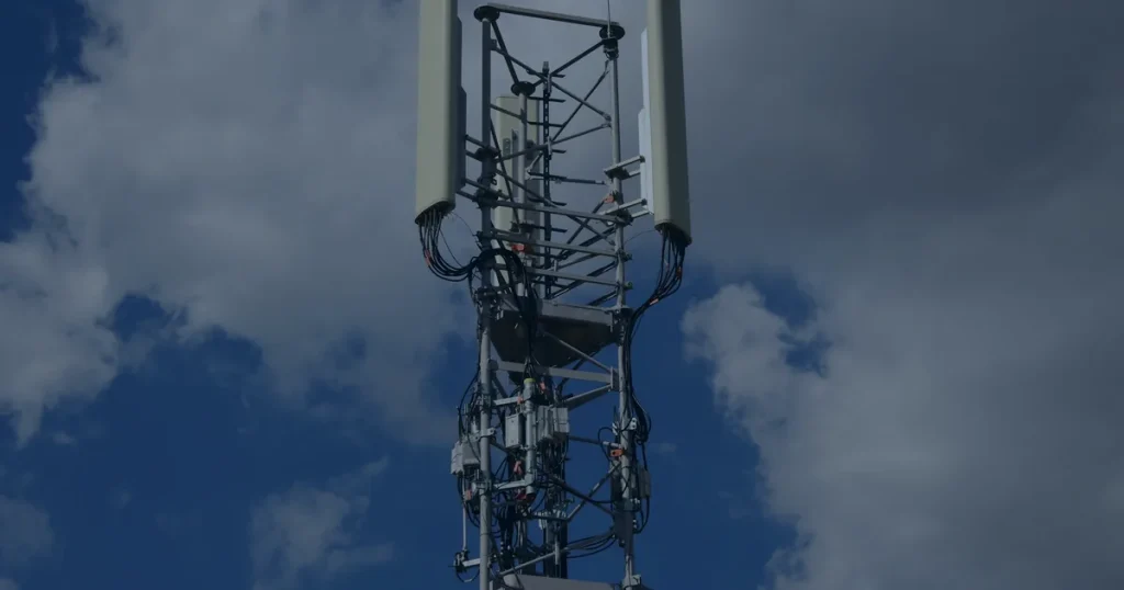 Torre de telefonia contra céu azul ilustrando o impacto do 5G nos negócios
