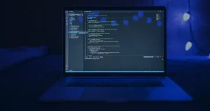 Tela de notebook com código em azul ilustrando como o ransomware funciona e se proteger