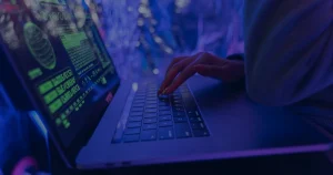 Mãos digitando em notebook azul ilustrando como criar senhas realmente seguras