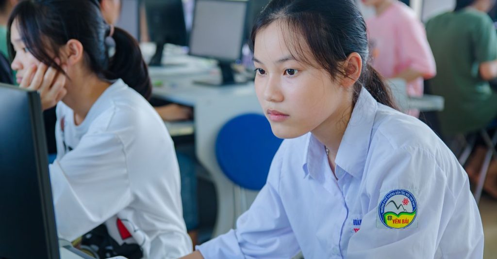 Estudantes em laboratório de informática em tons de azul