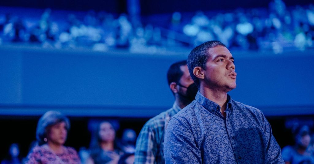 Público atento em tons de azul em grande evento de inovação e startups