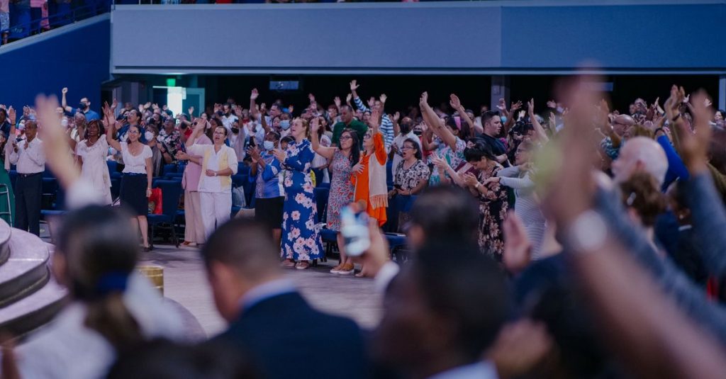 Plateia participativa em tons de azul em fórum de startups e inovação